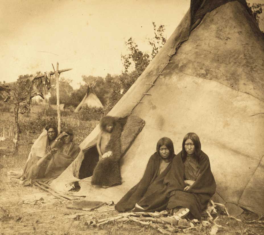 This family poses for a photo next to their tipi home