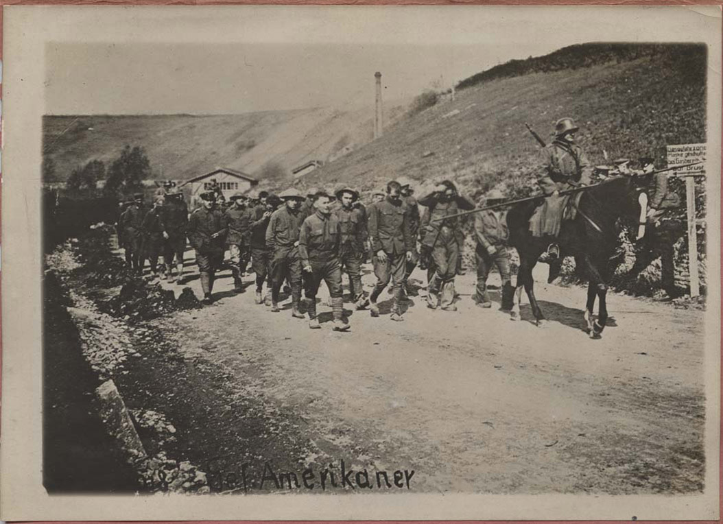 <span class='figure-reader-id'>Image 18:</span> 11086-85-01. When American soldiers were captured they were placed in German prisoner of war (POW) camps. These American soldiers were being marched to prison. The conditions of POW camps and the care of soldiers was governed by international law. <span class='figure-archive-id'>SHSND 11086-85-01.</span> 