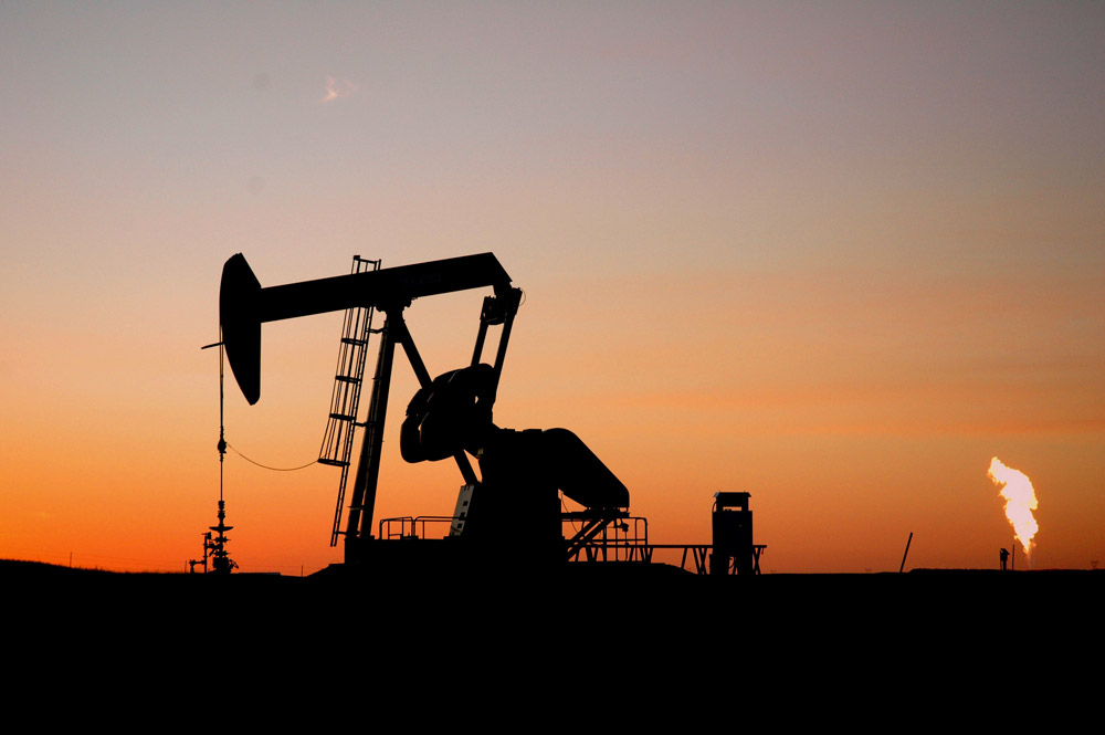 A pumpjack and a flare at night in North Dakota.