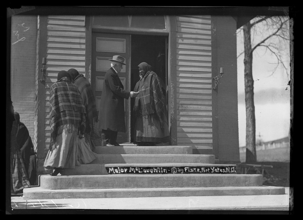 1952-1525 Major James McLaughin, reservation agent, shaking hands after mass at Catholic Church in Fort Yates