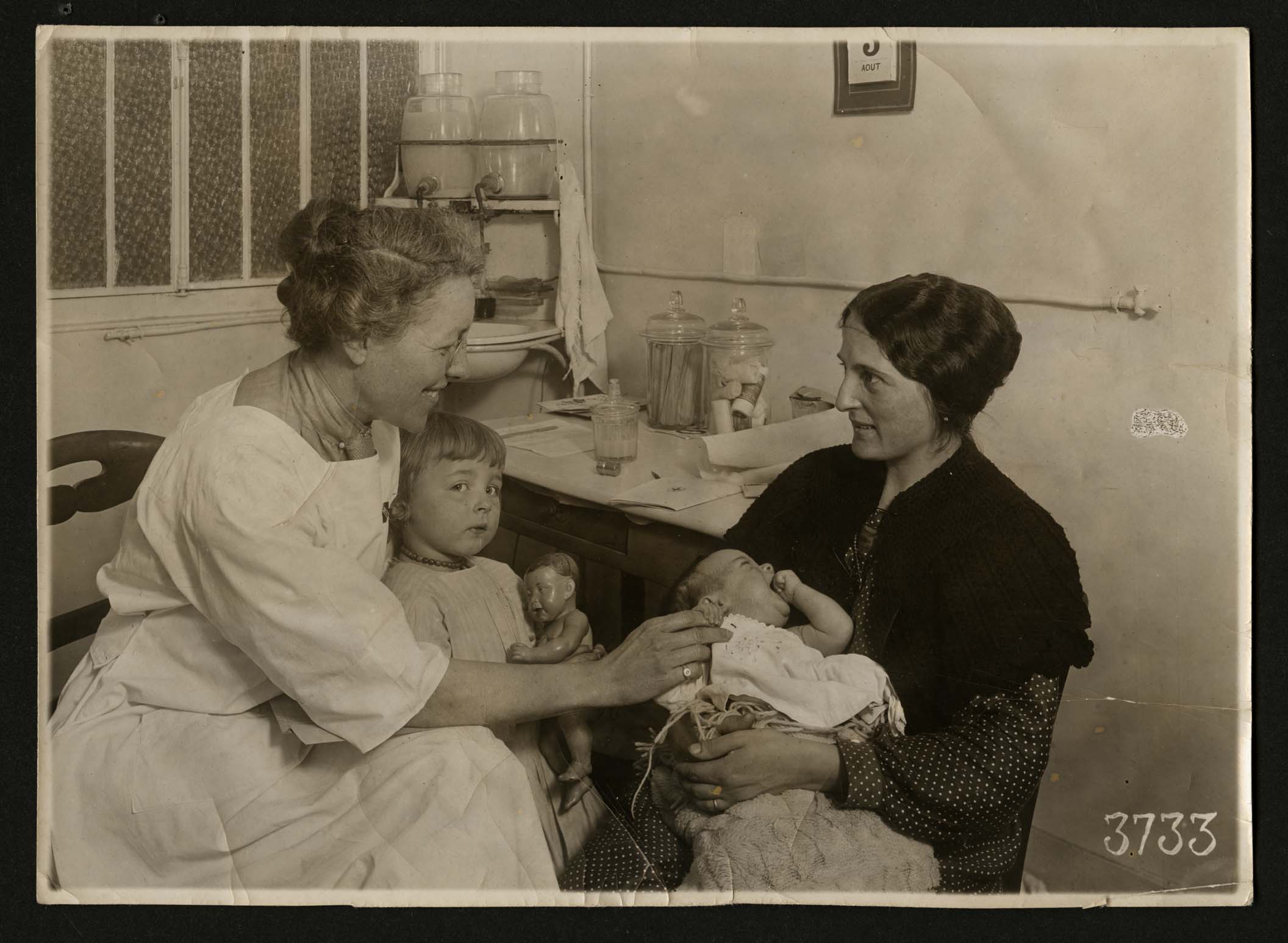 A mother brings her children to the American Red Cross Children's dispensary, Paris, France