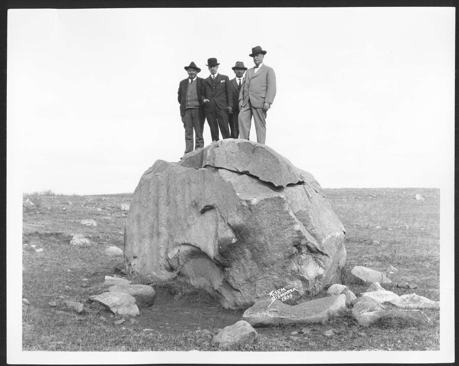Men atop the cornerstone boulder