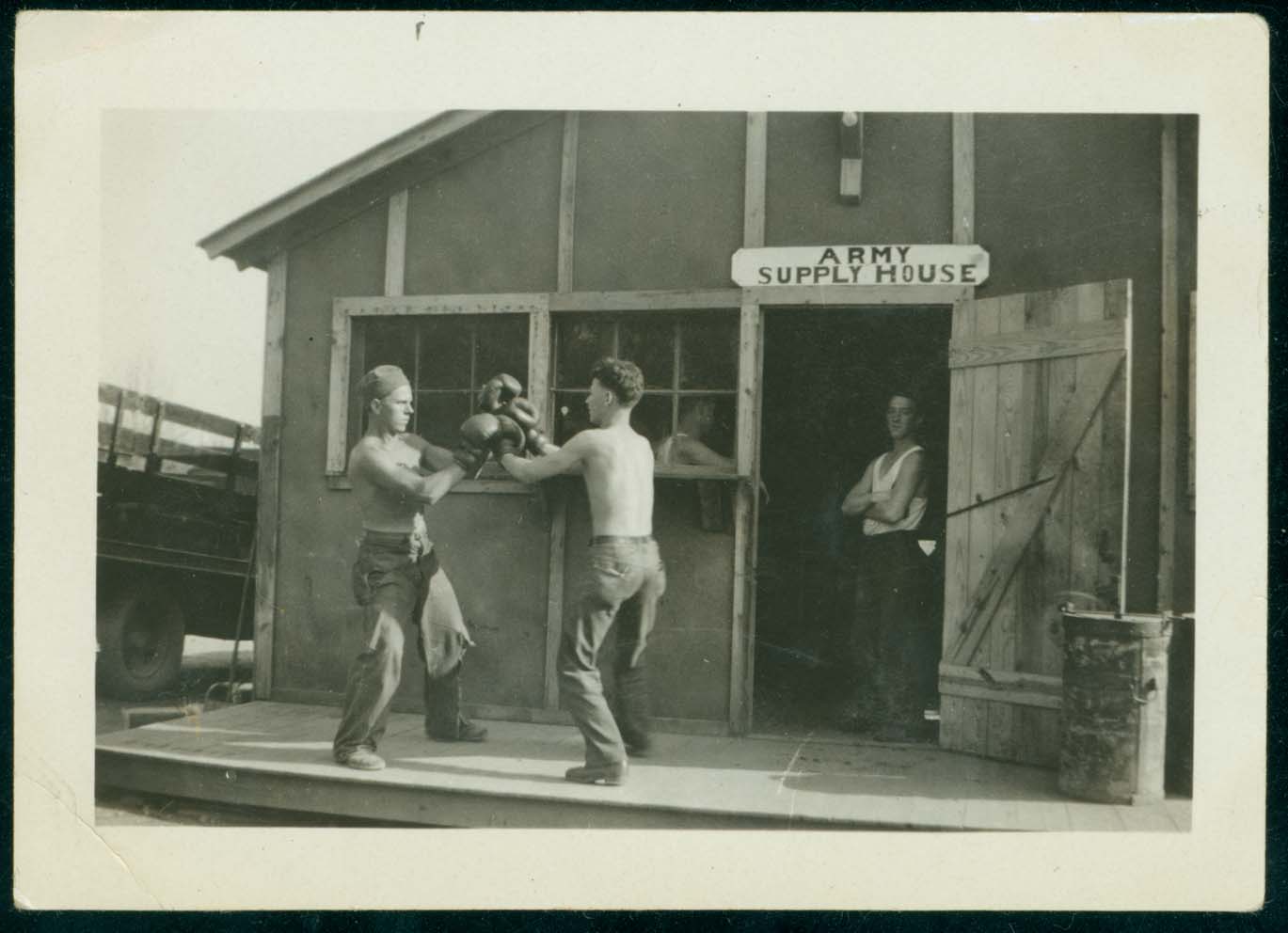 Unidentified men boxing outside of the Army Supply House at Camp Reform in Thornburg (Ark.), ca. 1934