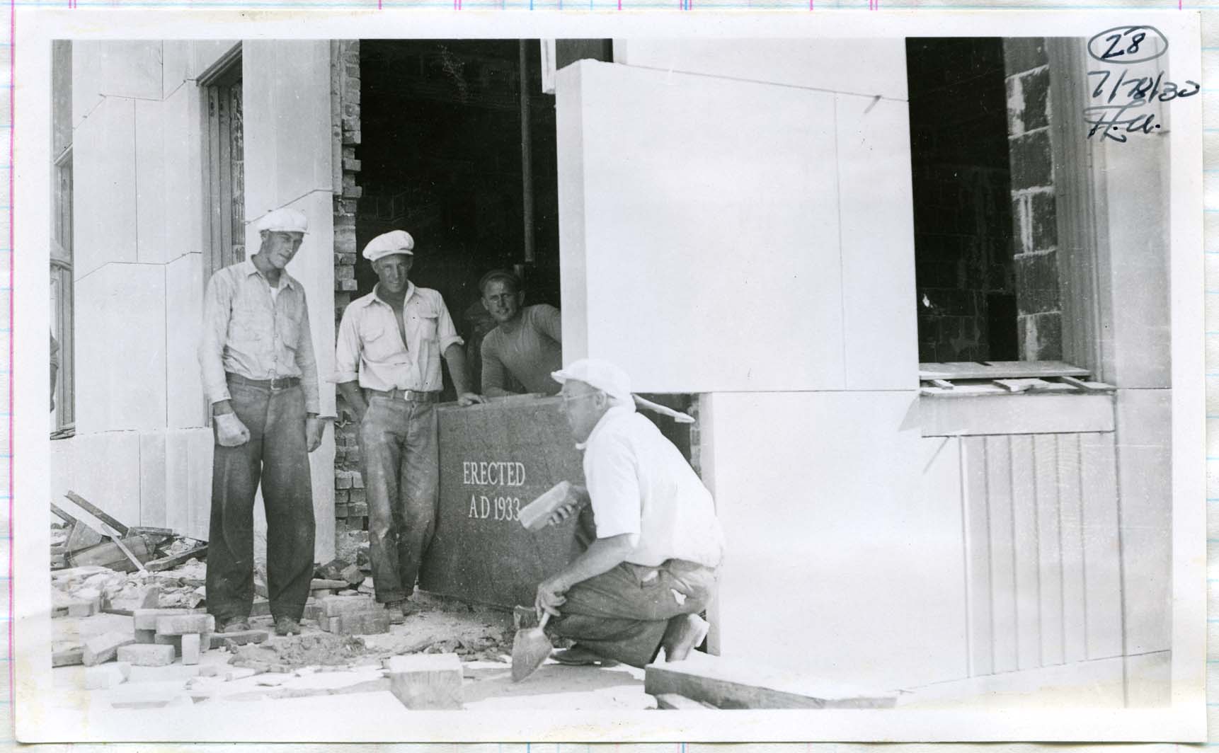 Workmen set the new cornerstone in place