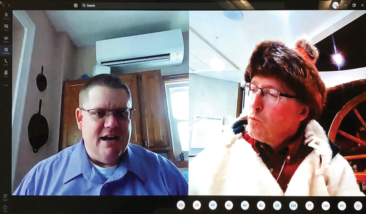 The left side of the screen shows a man wearing glasses and a blue button up shirt. The right side of the screen has a man with glasses wearing a fur hat and white jacket.